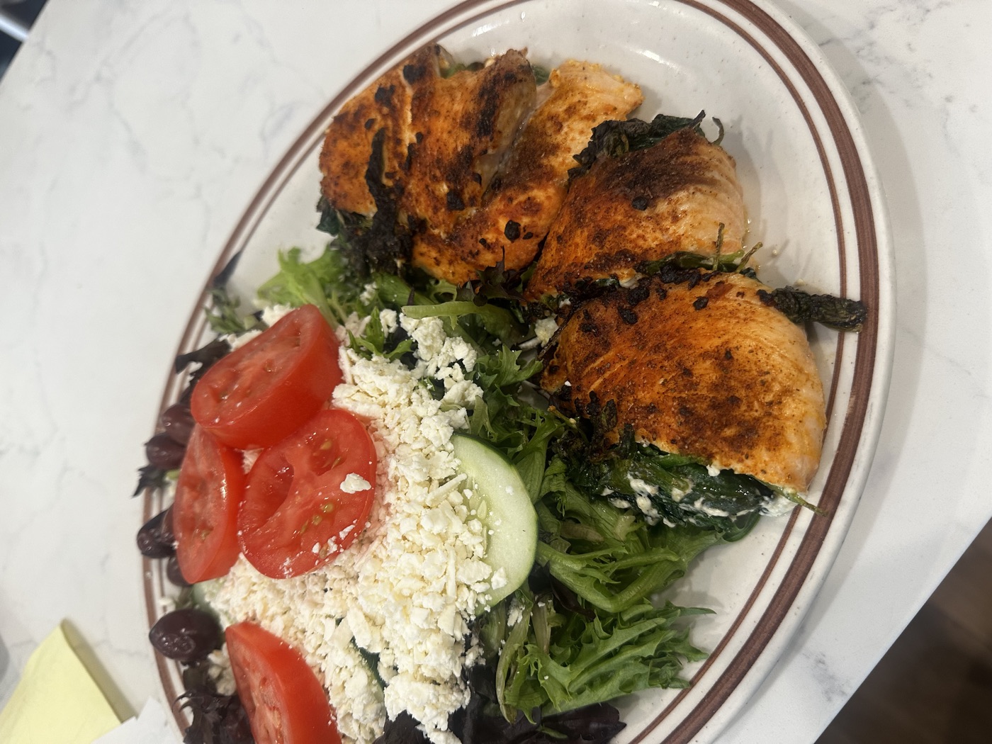 Grilled salmon served with Greek salad